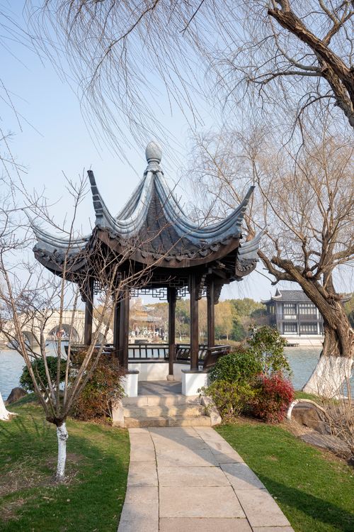 Free Beautiful traditional Chinese gazebo surrounded by nature in a serene lakeside setting. Stock Photo