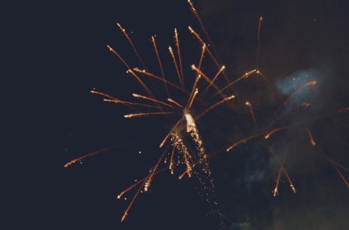 Free Illuminated fireworks burst against a clear night sky, creating a spectacular light show. Stock Photo