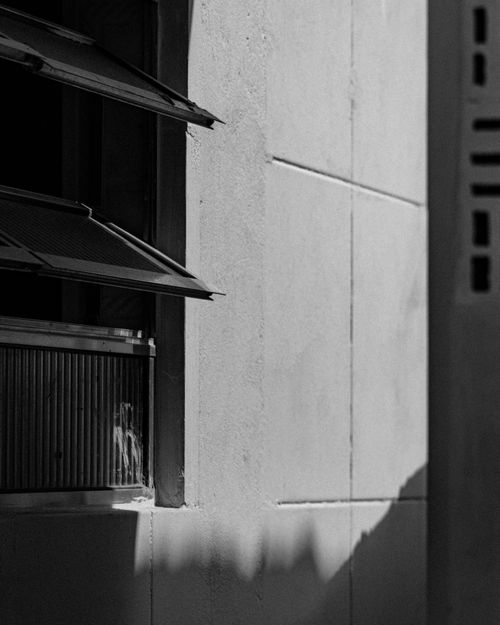 Free Black and white photo featuring geometric building design with open windows and shadows. Stock Photo