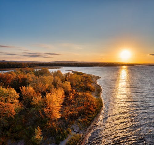 Sunset Over the River Amidst the Autumn Forest