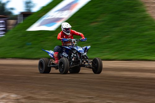 Free Dynamic image of a quad bike rider racing on a dirt track, showcasing speed and excitement. Stock Photo