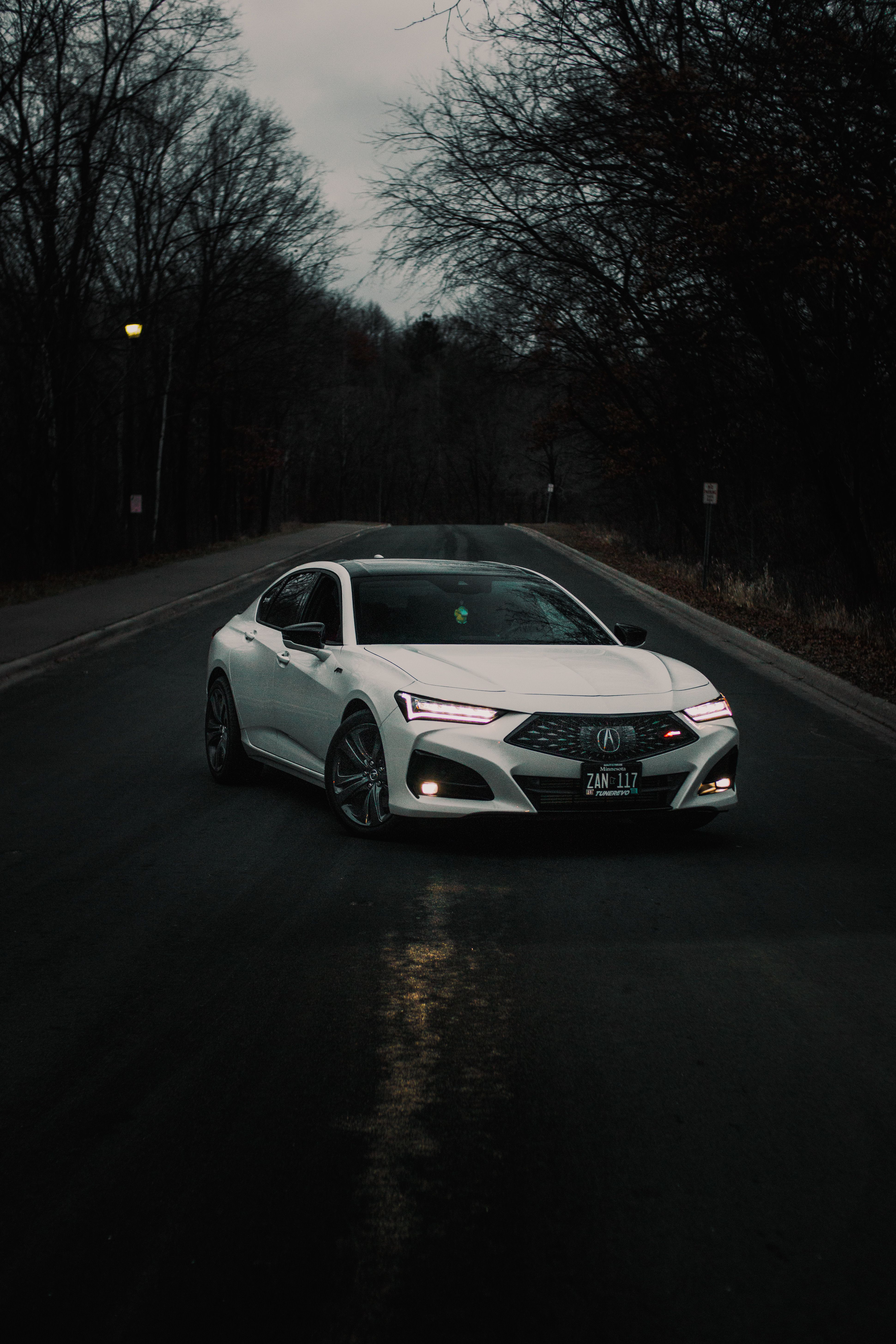 A white car driving down a road at night · Free Stock Photo