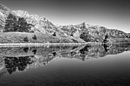 Black and white photo of mountains reflected in water