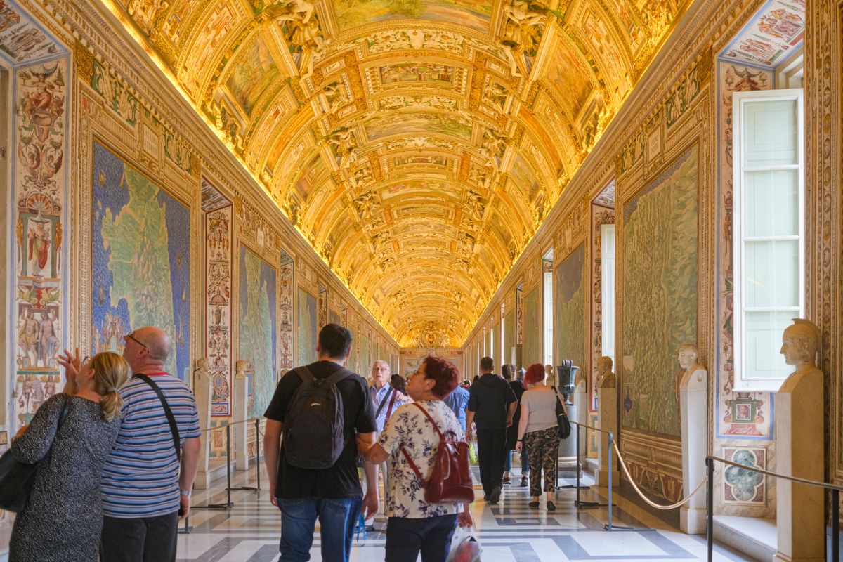 Galeria Hărților din Muzeele Vaticanului, cu tavanul boltit pictat și aurit, plină de vizitatori