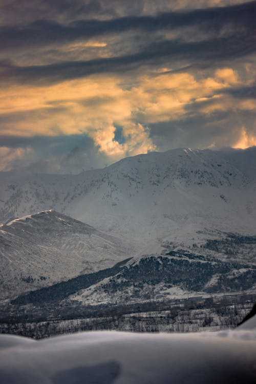 Snowy Mountains and Hills at Sunset