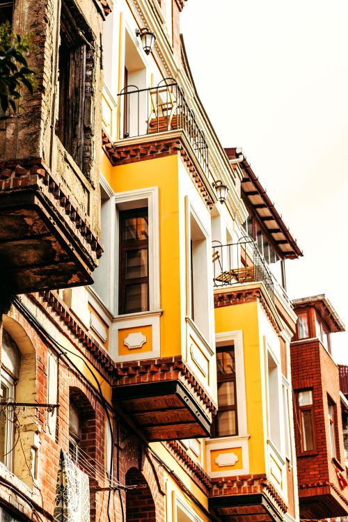 Free Vibrant yellow and red urban buildings in historical Istanbul, Turkey, capture sunlight and architectural charm. Stock Photo