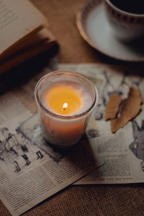 Free A cozy candlelit scene with vintage papers creating a warm, nostalgic atmosphere. Stock Photo