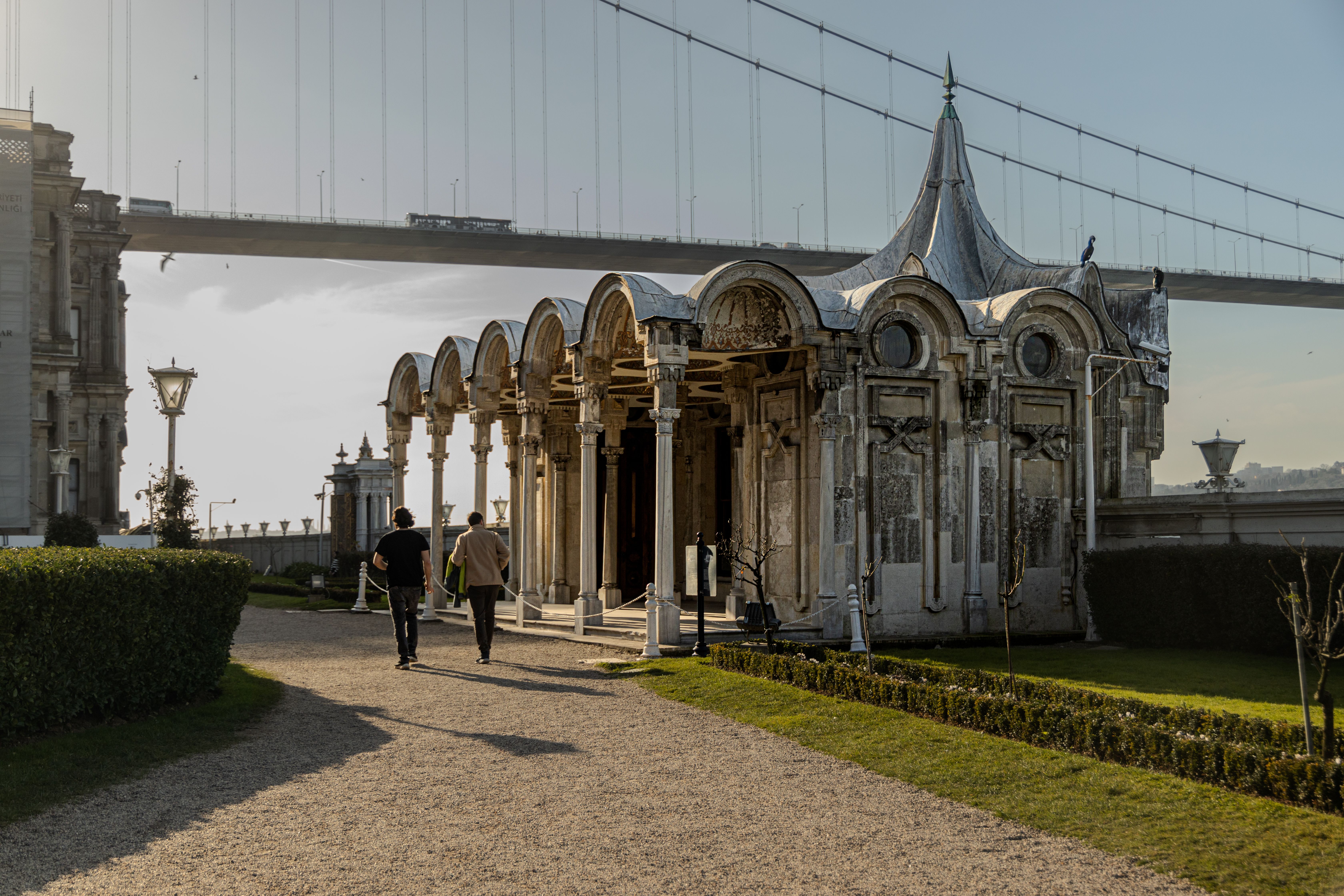 Scenic view of Beylerbeyi Palace and Bosphorus Bridge, Istanbul with people walking.