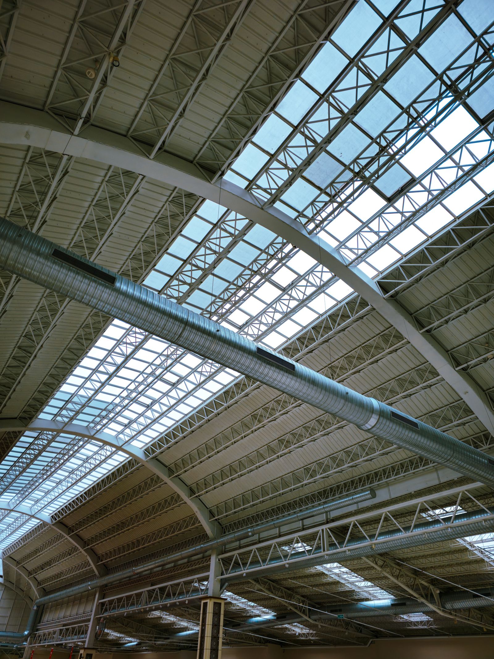 What happens when test and balance is skipped — large commercial warehouse with curved roof and exposed HVAC