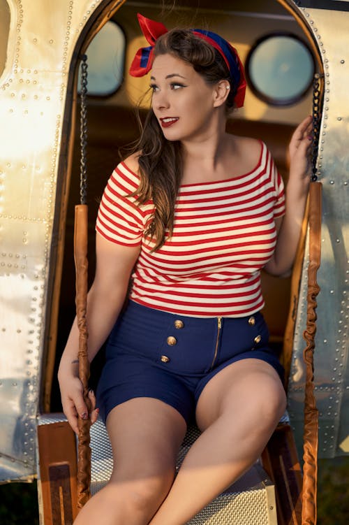 Woman Sitting in Striped Blouse and Shorts