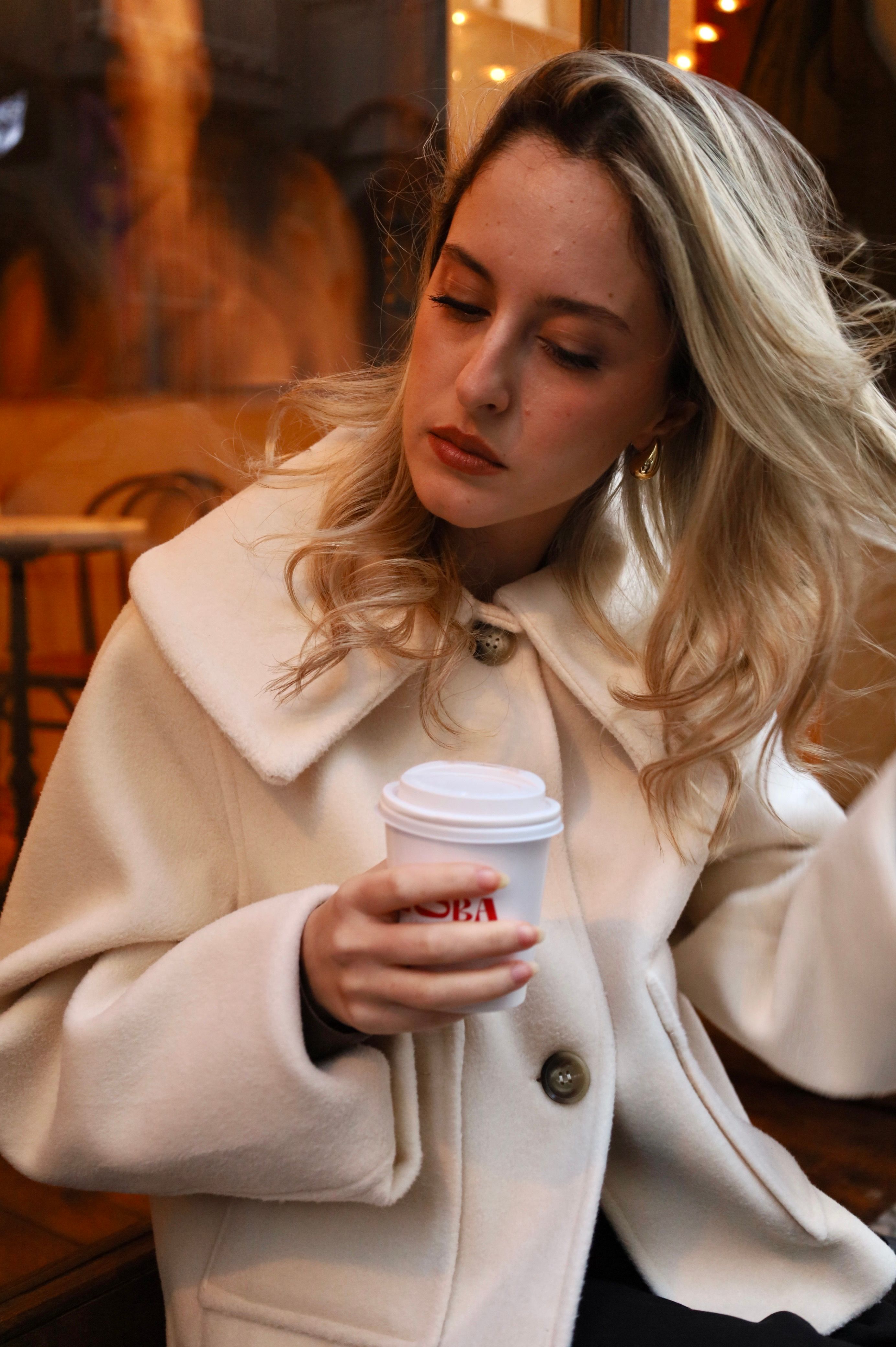 Young Woman in an Elegant Coat Holding a Cup · Free Stock Photo