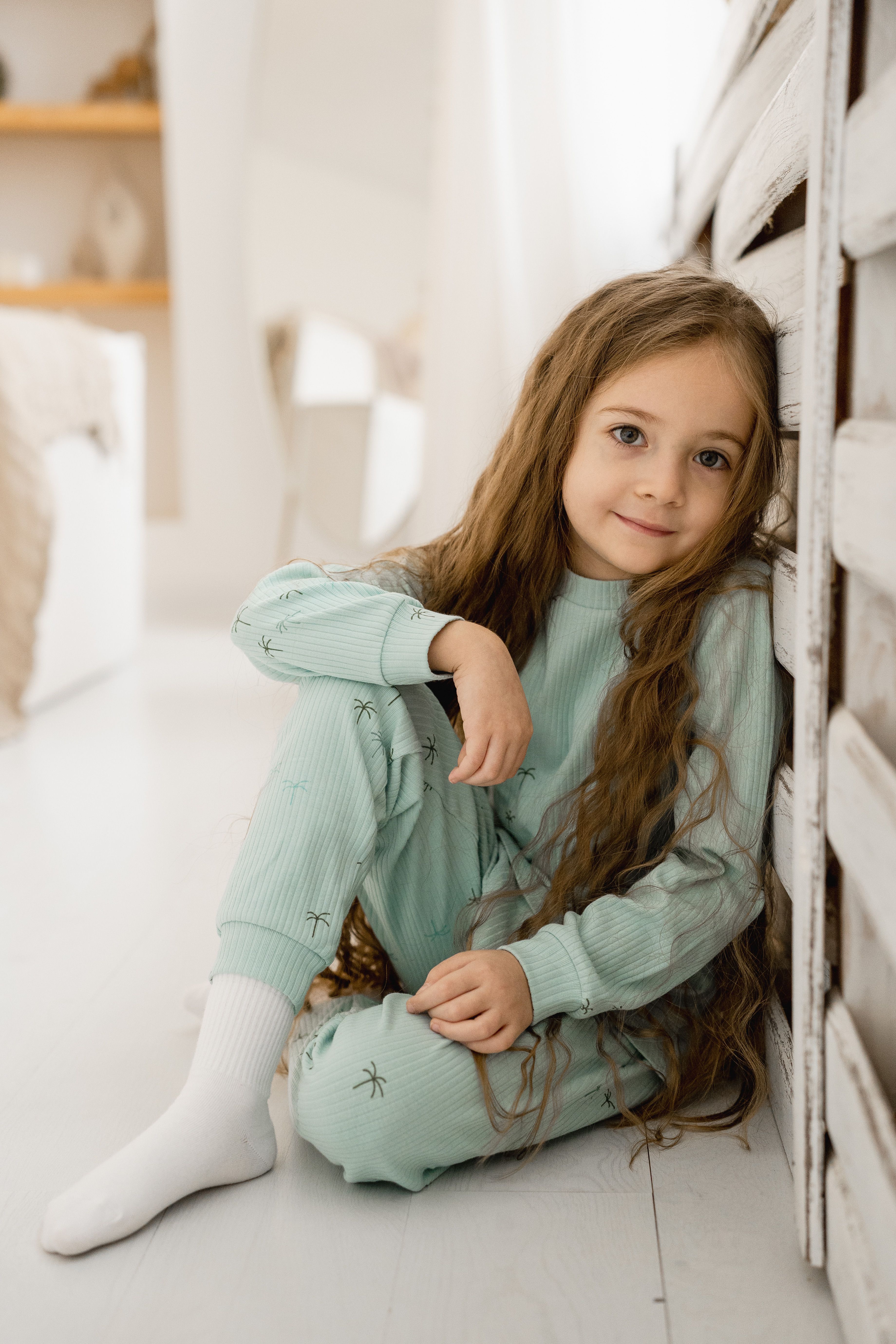 A Little Girl in Pajamas Sitting in Her Room and Smiling · Free Stock Photo