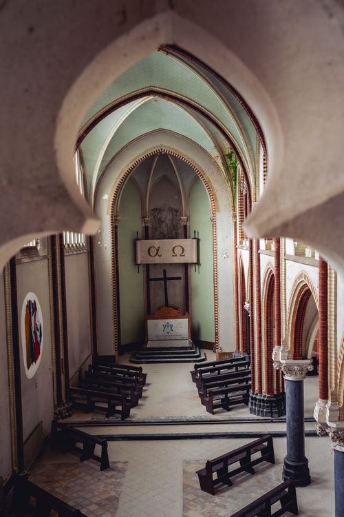Free A beautifully designed gothic church interior with arches, benches, and religious symbols. Stock Photo