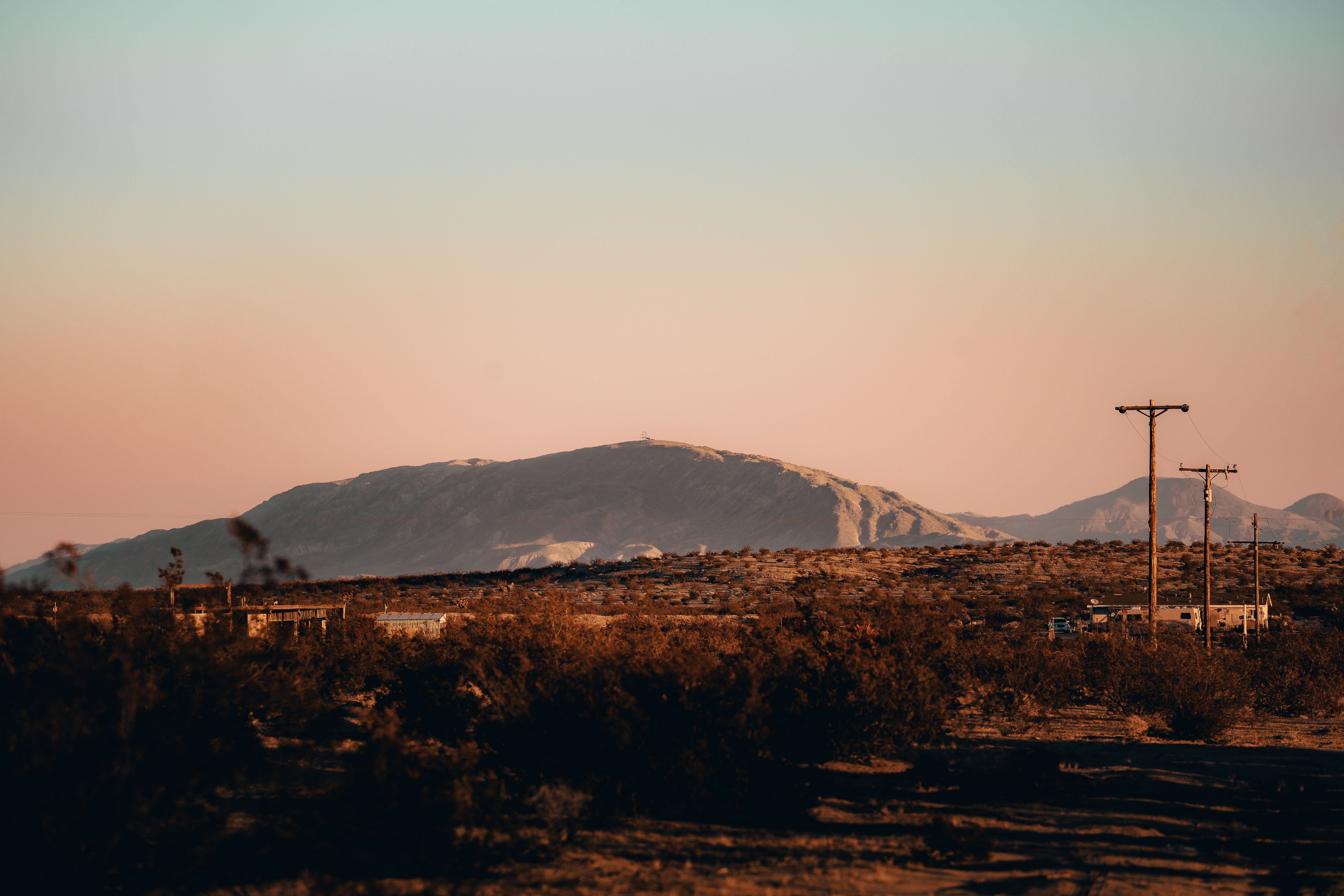A minimalist luxury retreat seamlessly integrated into a vast desert landscape under a twilight sky.