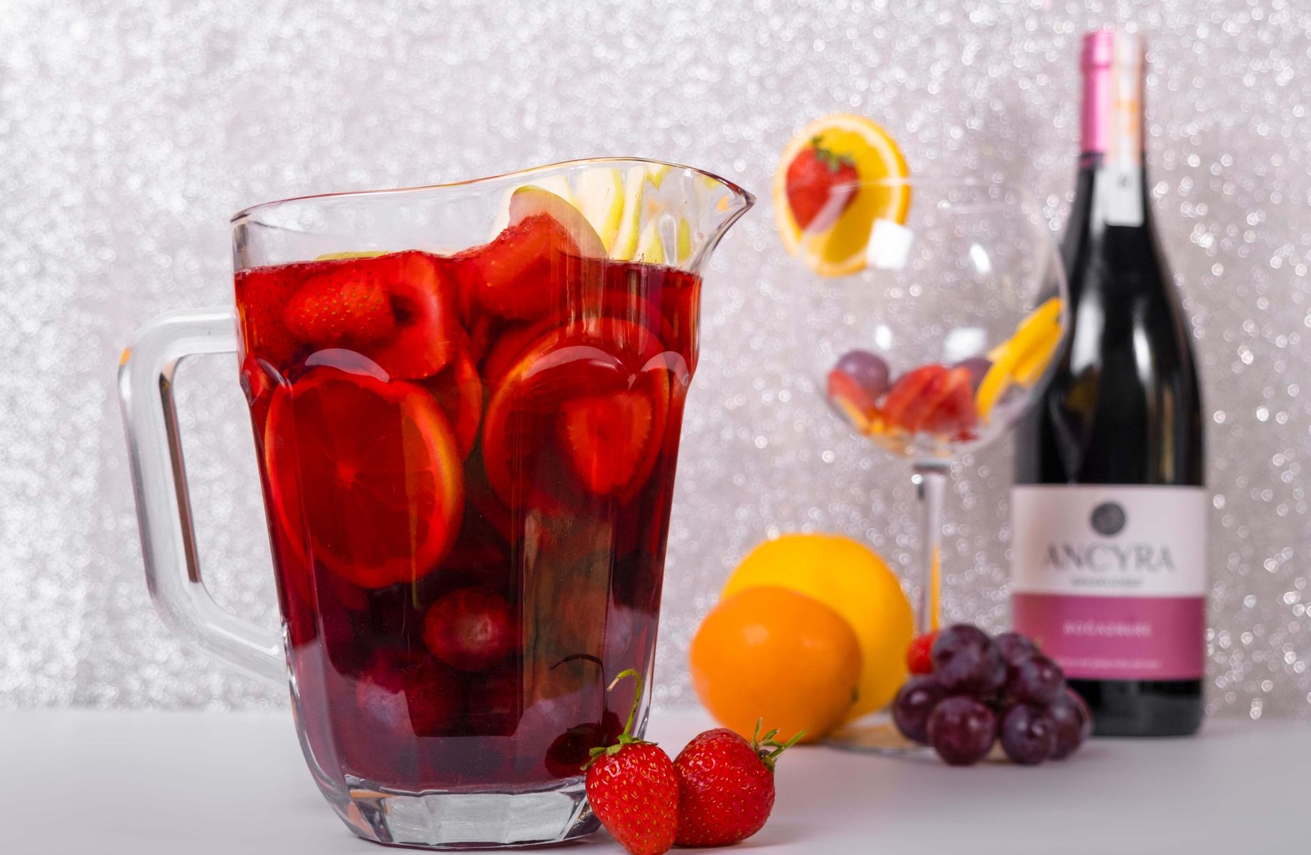 Glass of passion fruit sangria garnished with fresh fruit slices