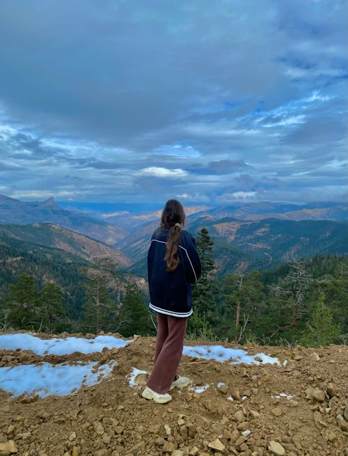 Back View of a Woman Standing on a Mountain Peak 