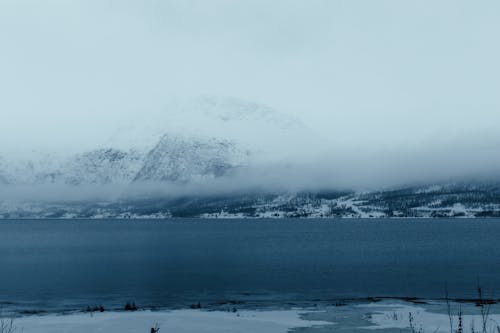 A view of a lake and mountains in the snow