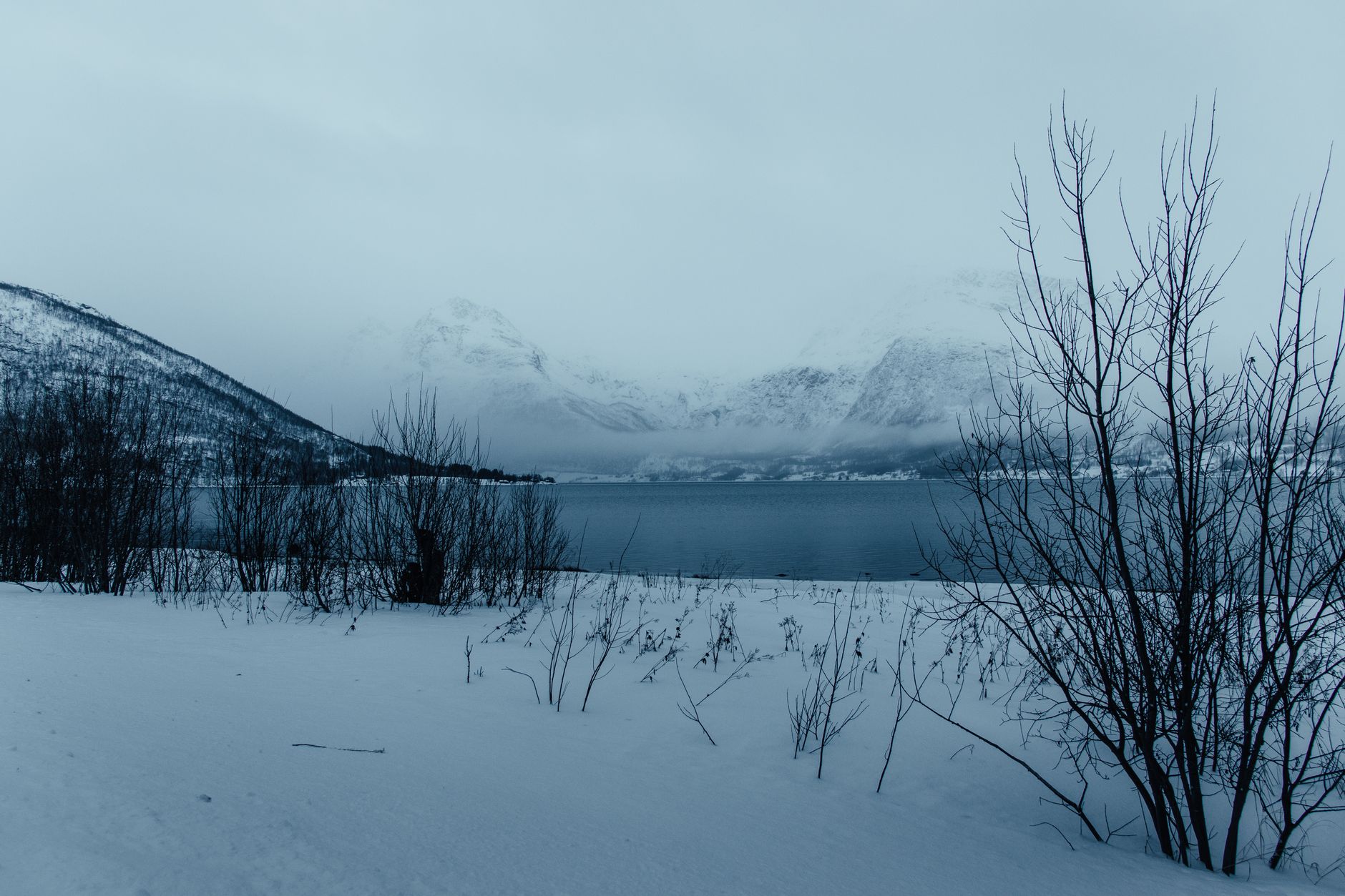 Stunning winter scene in Laksvatn, Norway, with snow-covered terrain and serene lake.