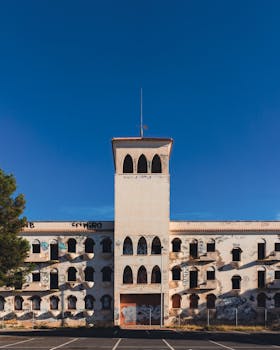 An abandoned tower building in San Javier, Spain, with a clear blue sky.