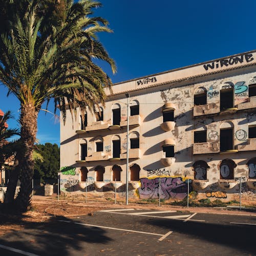 A building with graffiti on it and palm trees