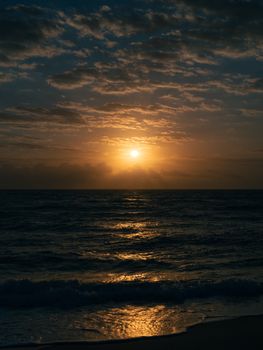 Captivating sunset over the ocean with a dramatic sky and gentle waves.