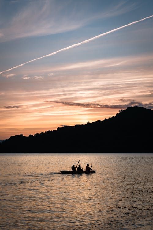 Two people in a boat at sunset on a lake