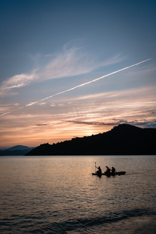 Two people in a canoe at sunset on a lake