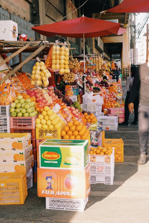 A man walking down a street with a bunch of fruit