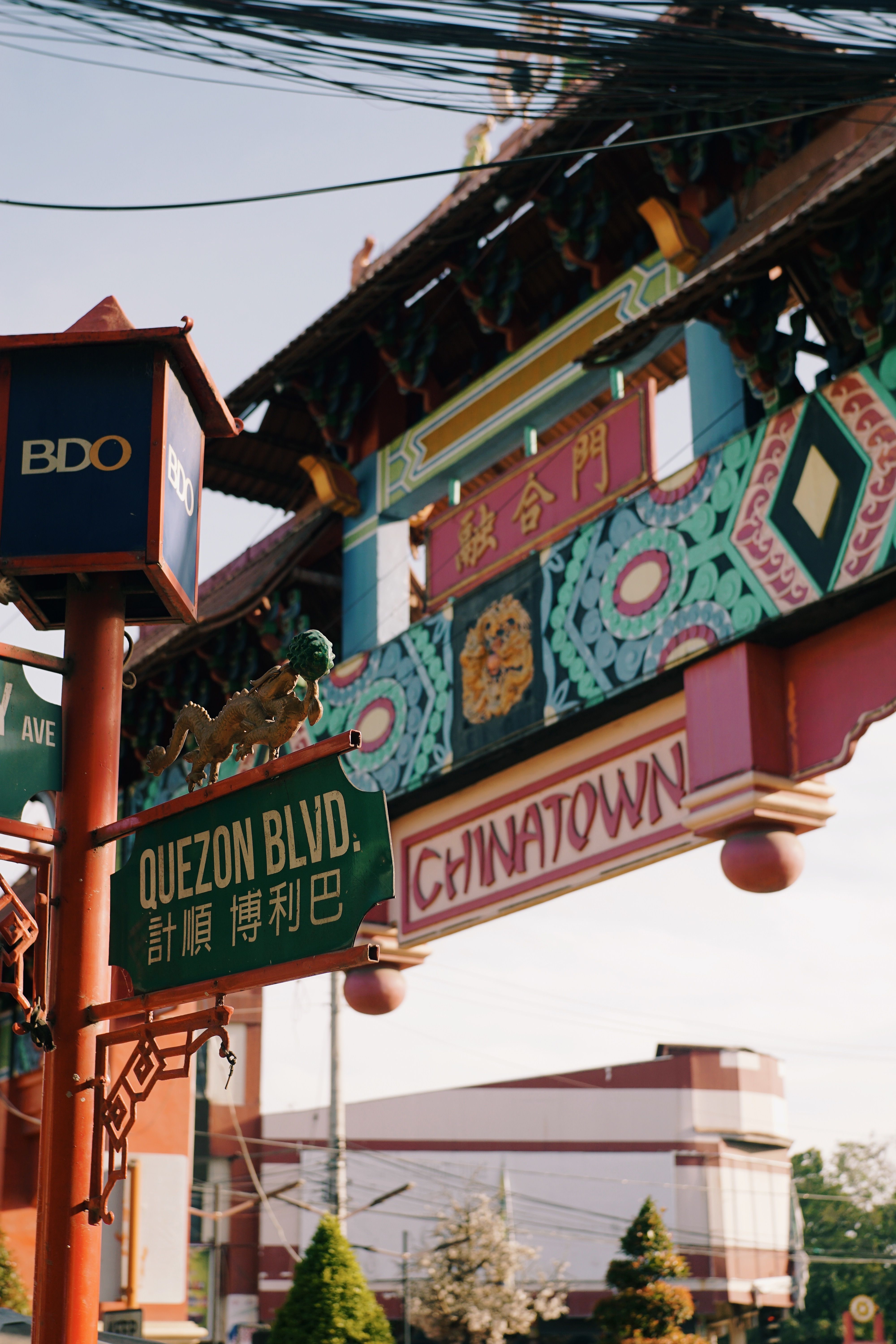 Ornate Chinatown gate with street signs at Quezon Blvd, vibrant cultural symbol.