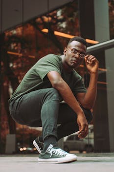 这是一幅充满活力的绿色调当代肖像，捕捉了一位年轻人在户外自信摆姿的瞬间