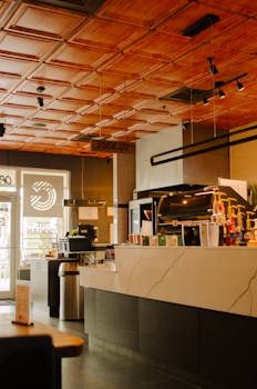 Warm café interior showcasing modern design and a sleek coffee counter.