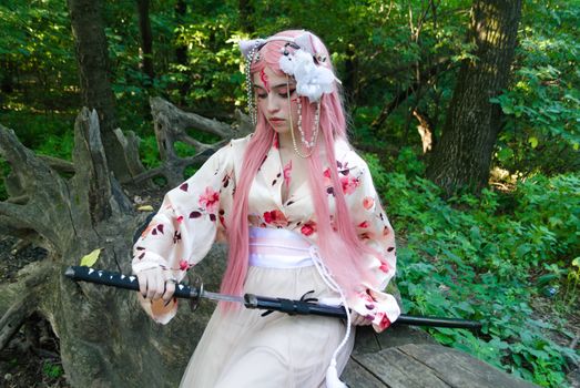 A woman in cherry blossom kimono and pink hair poses with katana in a lush forest setting.