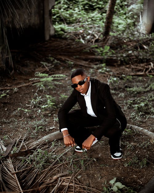 Foto profissional grátis de agachado, floresta, homem afro-americano