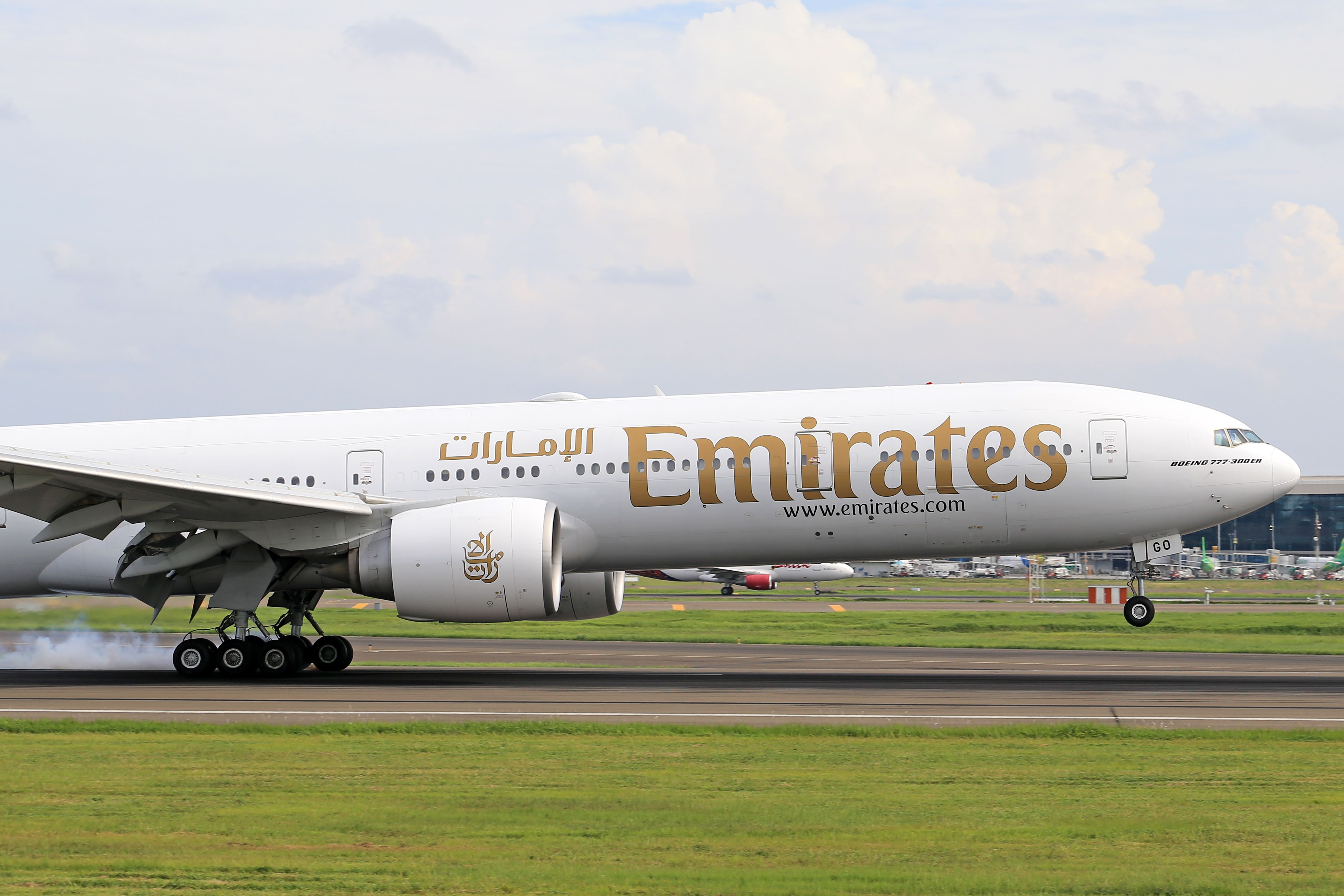 Emirates airplane parked at Dubai International Airport terminal
