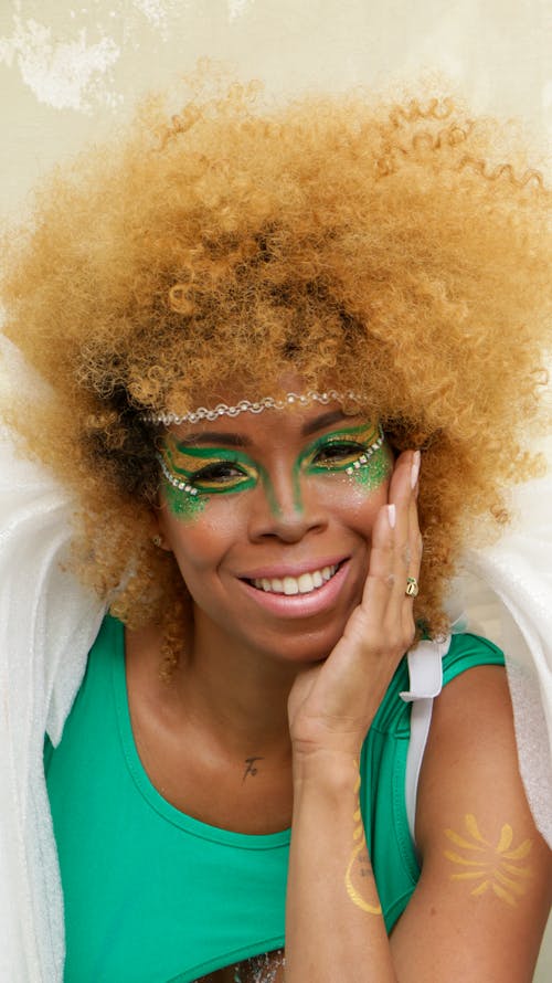 A woman with green face paint and a green dress
