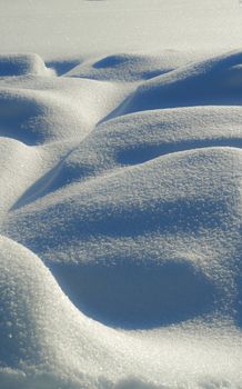 Close-up view of snowdrifts showcasing untouched winter beauty with textured surfaces.
