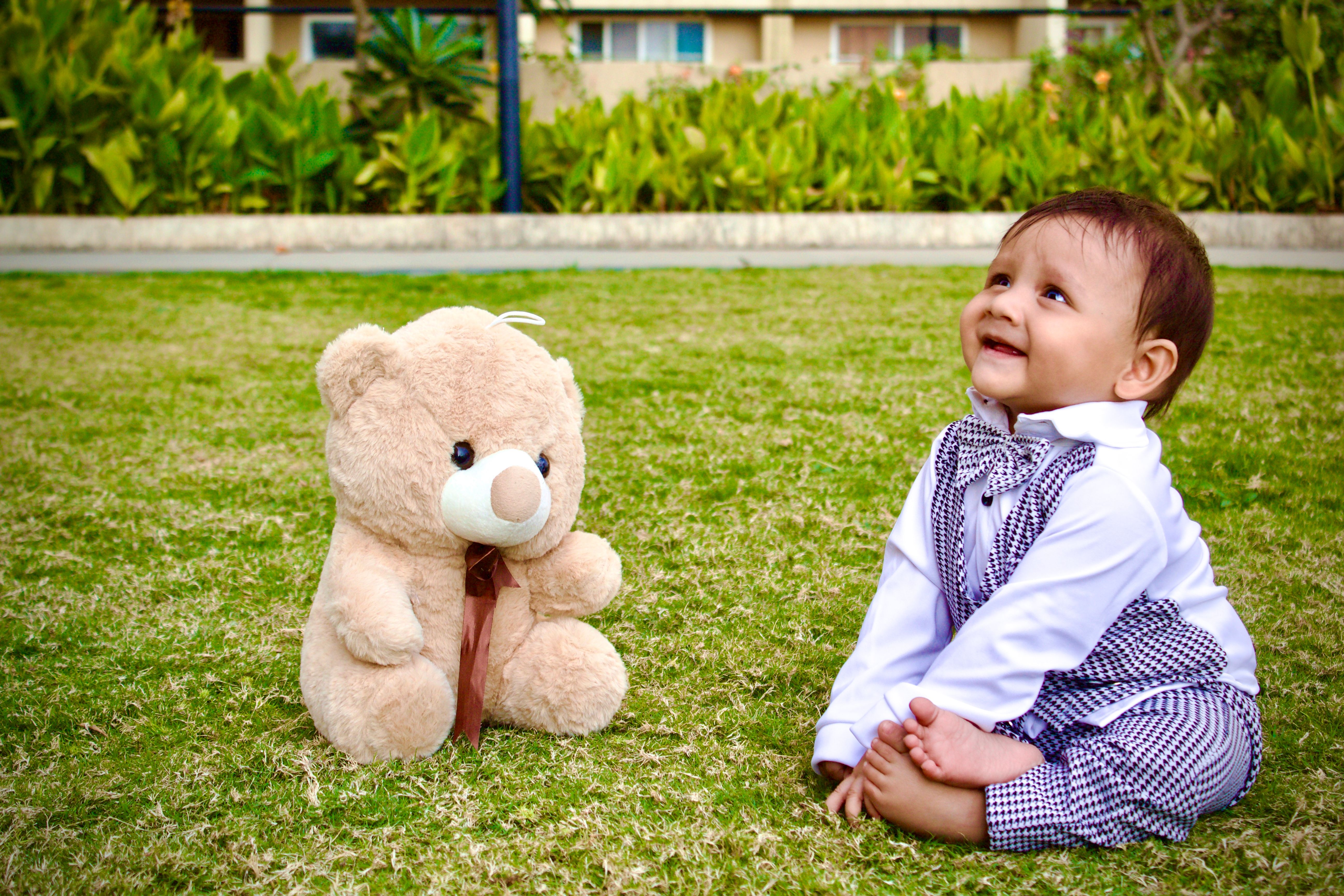 Baby Boy Sitting with a Teddy Bear on a Lawn · Free Stock Photo