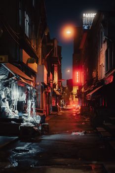 Atmospheric view of a narrow Istanbul alley at night with neon lights and a moody vibe.