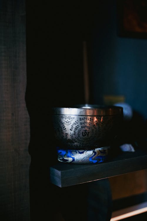 A bowl sitting on a shelf in a dark room