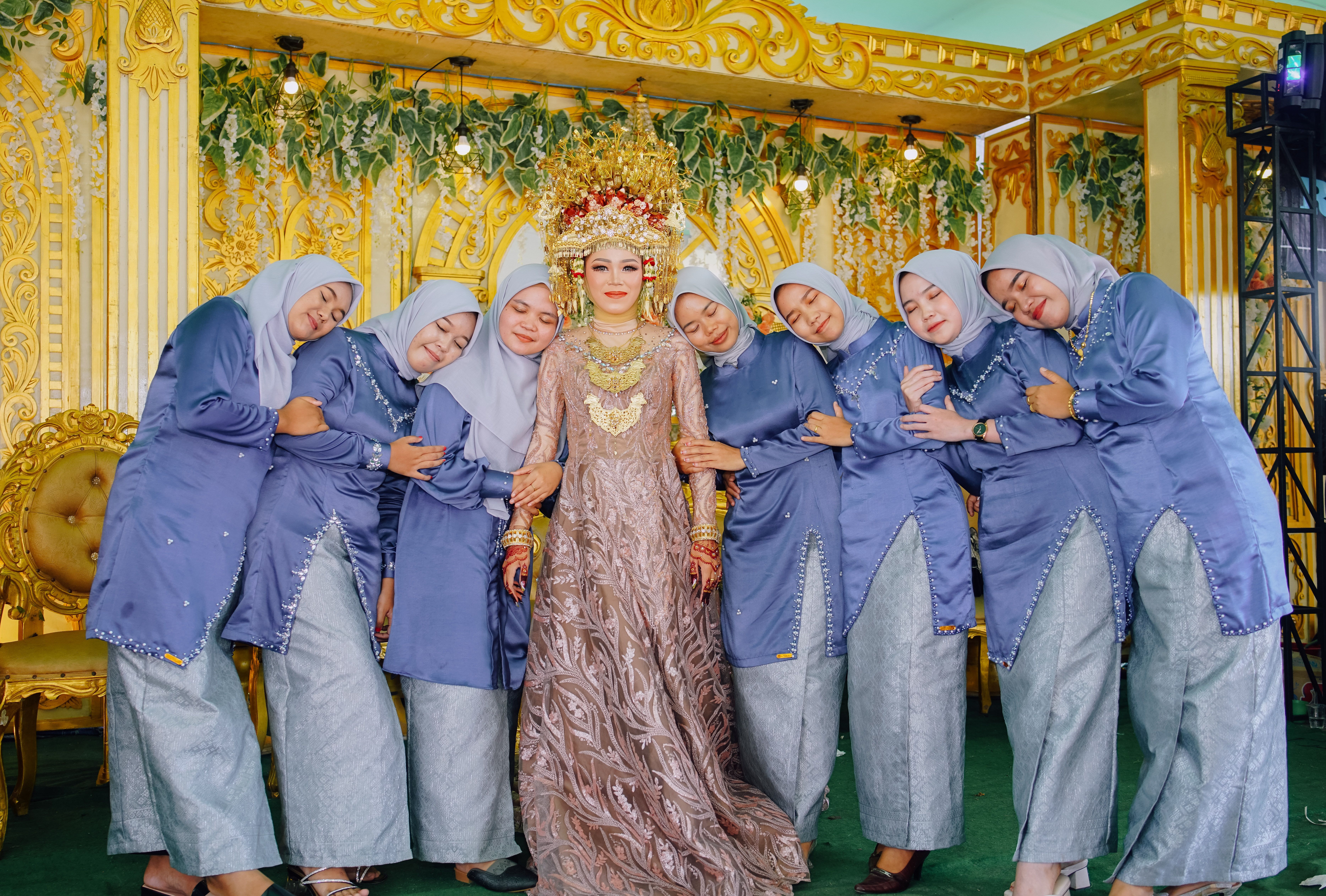 A beautiful bride with her bridesmaids in traditional Indonesian wedding attire, celebrating joyfully.