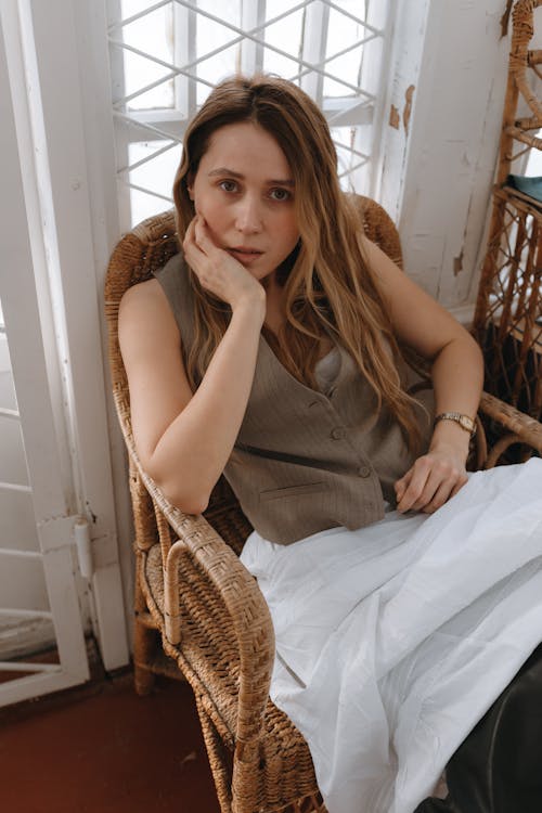 Young, Fashionable Woman Sitting on a Chair in a Room 