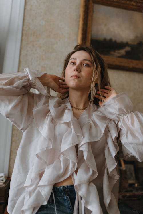 A woman in jeans and a ruffled blouse