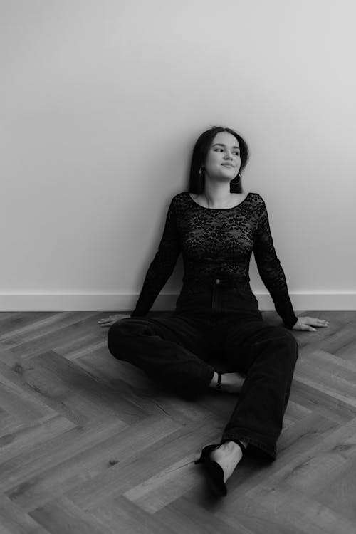 Smiling Woman Sitting on Floor in Black and White