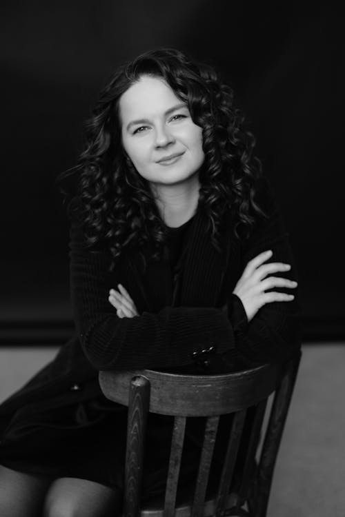 A woman with curly hair sitting on a chair