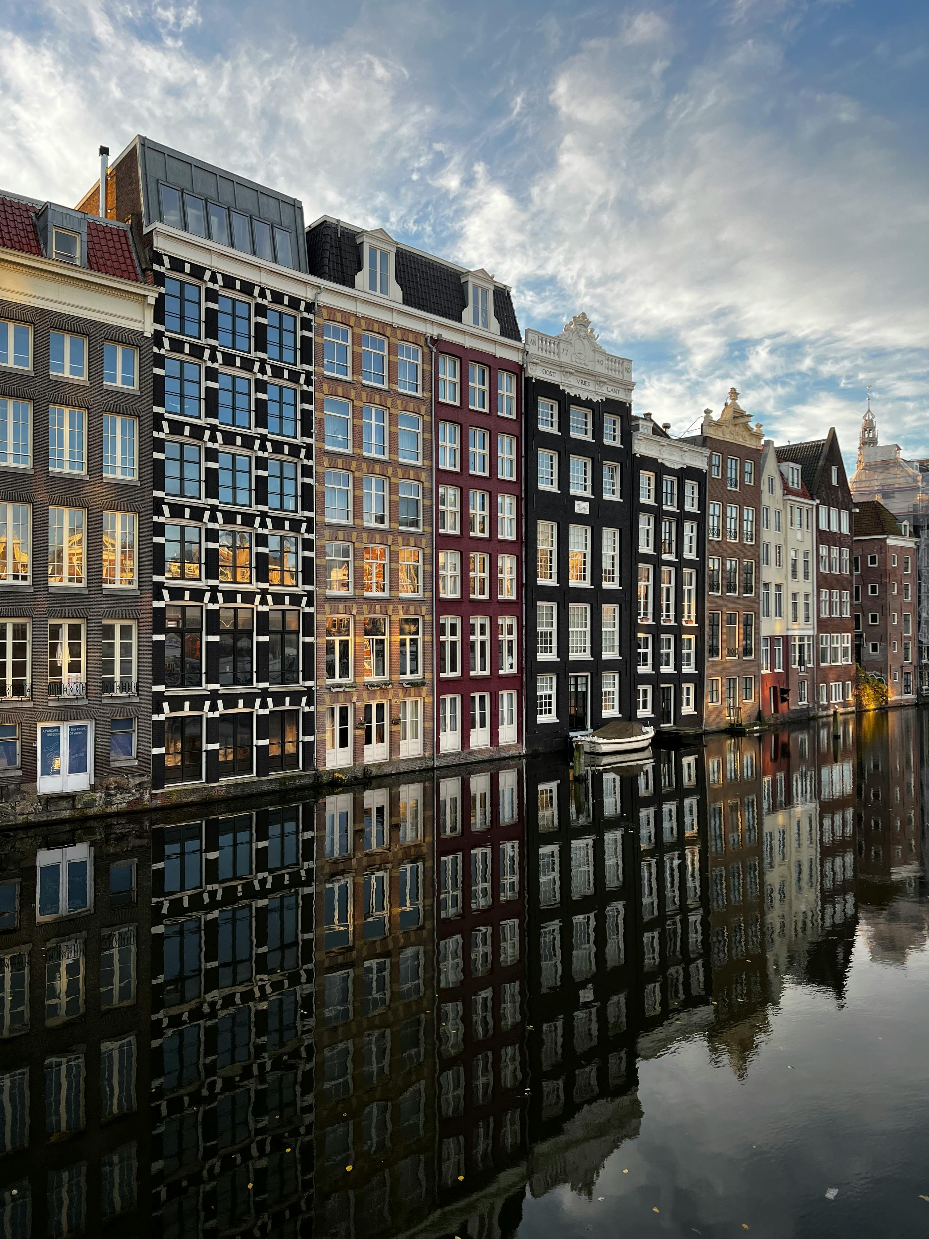 Beautiful reflection of Amsterdam canal houses at dusk.