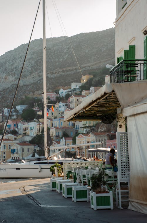 View of a Cafe and Cliffside Buildings on Symi Island on the Aegean Sea Shore in Greece