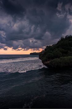 A dramatic coastal scene with storm clouds at twilight, showcasing nature's raw beauty.