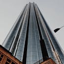 从低角度仰望阿联酋阿布扎比一座高耸的现代摩天大楼，展现城市建筑风貌