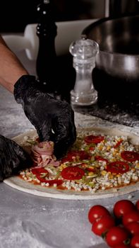 A chef prepares a delicious pizza with fresh ingredients in a kitchen setting.