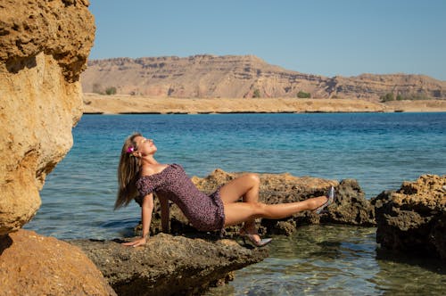 A woman laying on rocks in the water